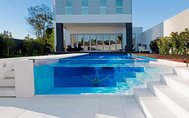 Piscina con pared de vidrio rebosante